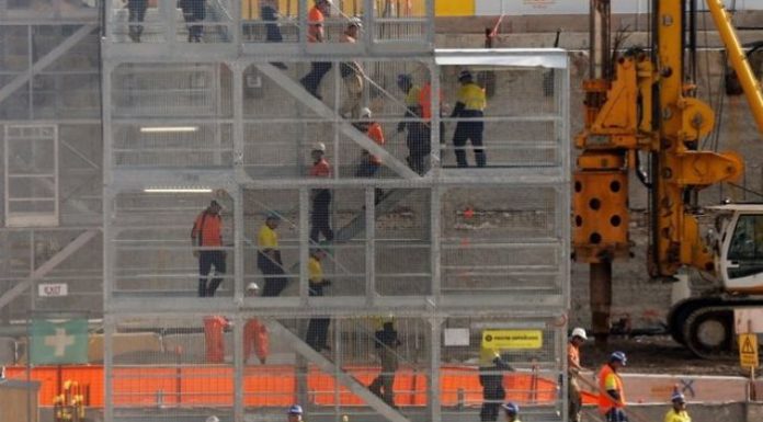 Construction workers descend using temporary stairs on a major construction site in central Sydney